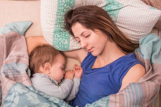 Shutterstock photo/Mother sleeping with baby