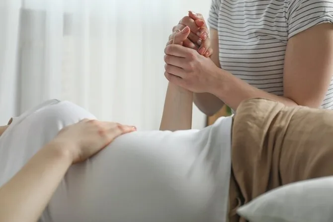 Shutterstock photo/Doula with a birthing woman