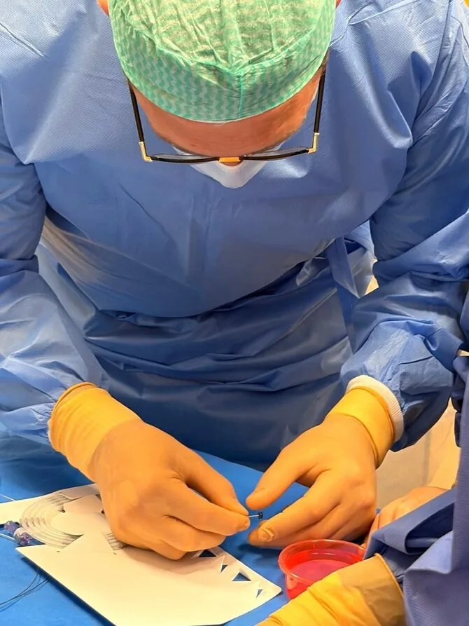 Santaros klinikų nuotr./Atviro arterinio latako minimaliai invazinė procedūra: implantas gydytojo S. Čėsnos rankose
